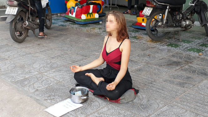 Cô gái Nga ngồi thiền xin tiền tại Phú Quốc - Ảnh: H.TRUNG