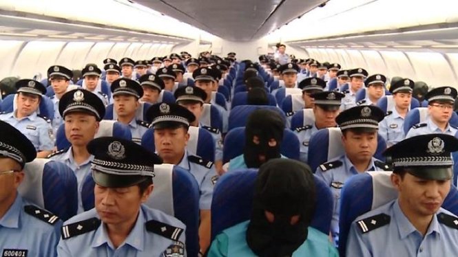 Các nghi phạm (hàng ngồi giữa) bị dẫn độ trên máy bay từ Fiji về Trung Quốc - Ảnh: TWITTER
