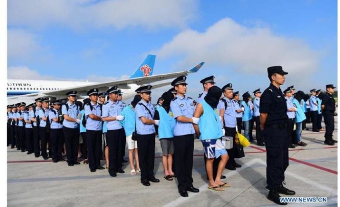 Các đối tượng lừa đảo người Trung Quốc bị dẫn độ về từ Fiji, xếp hàng ở sân bay trước khi vào tù - Ảnh: TWITTER