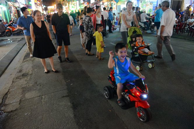 Các em nhỏ thích thú chạy xe trên phố đi bộ Bùi Viện tối 20-8 - Ảnh: QUANG ĐỊNH