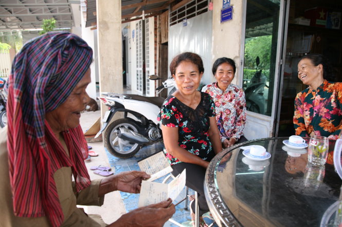 Bà Lâm Thị Đẹp ở Ninh Thạnh (TP Tây Ninh) xem lại những giấy tờ với tên gọi dân tộc Tà Mun được cấp nhiều năm trước - Ảnh: VIỄN SỰ