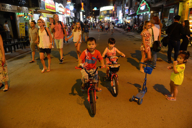 Các em nhỏ đạp xe đạp trên phố đi bộ Bùi Viện tối 20-8 - Ảnh: QUANG ĐỊNH