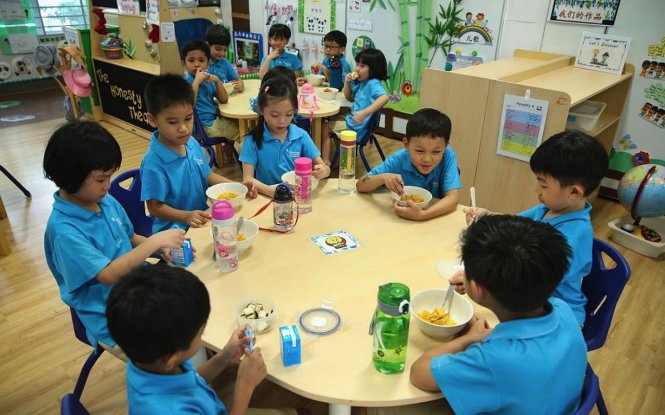 Các em nhỏ đang ăn bữa phụ tại một trường mầm non ở Singapore - Ảnh: Bộ thông tin truyền thông Singapore/Straitstimes