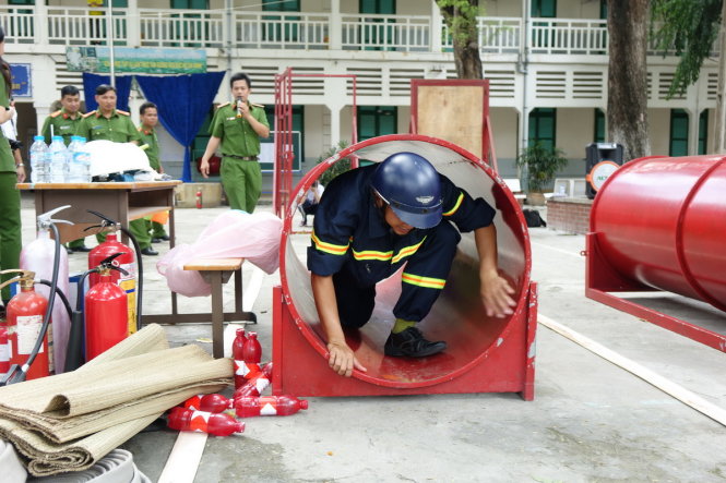 Các chiến sĩ CS PCCC đang hướng dẫn học sinh và thầy cô trường THPT Lê Quý Đôn Q3, TPHCM thực hành các động tác cứu người thoát khỏi đám cháy