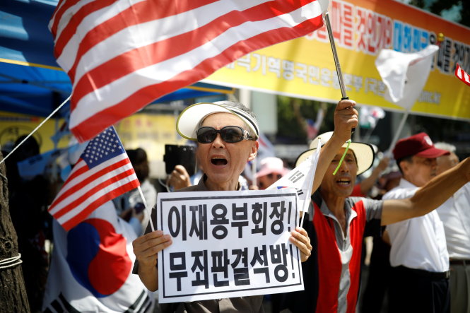 Một nhóm người dân Hàn Quốc biểu tình trước Tòa án quận trung tâm Seoul với biển ghi