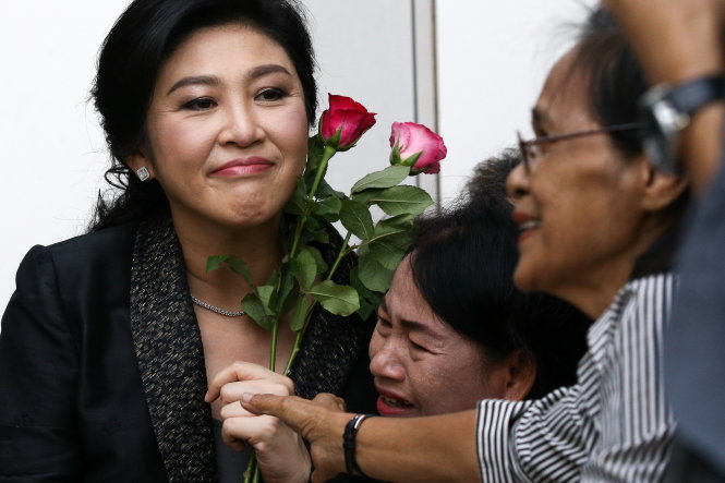 Người ủng hộ bà Yingluck khóc nức nở ôm chầm lấy bà và tặng hoa khi bà ra tòa hôm 1-8 ở Bangkok - Ảnh: REUTERS