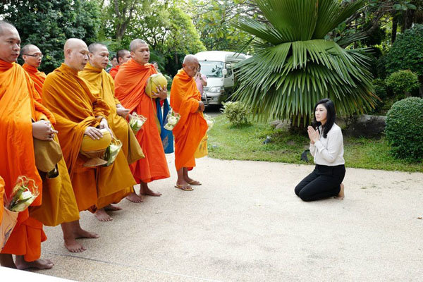 Bà Yingluck chủ động đưa hình ảnh quì cúng các nhà sư lên Facebook vào ngày 23-8, thời điểm được cho là bà bắt đầu bí mật rời khỏi Thái Lan - Ảnh: Facebook