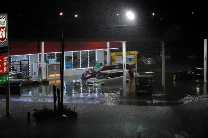 Một trạm xăng vắng tanh, xe cộ bị ngập trong nước lũ ở Houston - Ảnh: REUTERS