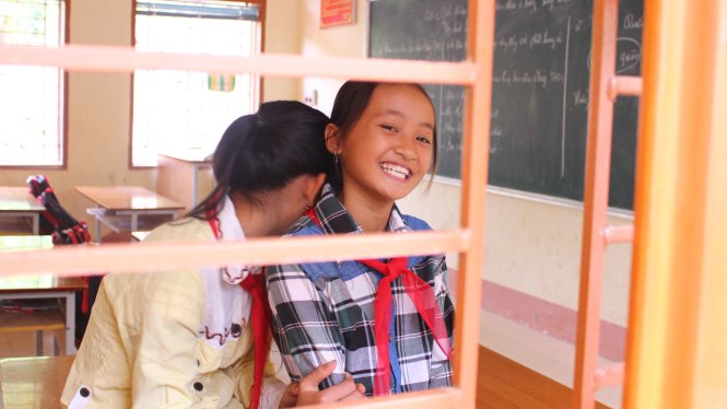 Trong ảnh là cô bé Cà Thị Kim (bìa phải, lớp 6B Trường THCS Nặm Păm) với nụ cười rạng rỡ. Dù nhà cửa bị mất trắng sau cơn lũ, nhưng được thầy cô giáo động viên, Kim vẫn tiếp tục đến trường - Ảnh: HÀ THANH