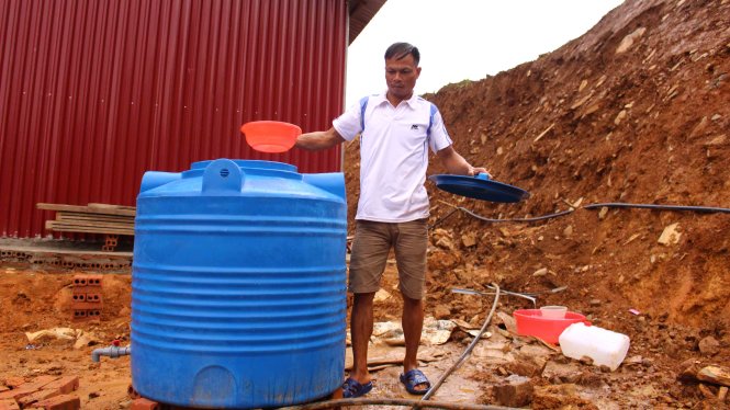 Bên cạnh hỗ trợ nhà ở, chính quyền huyện còn trao cho mỗi hộ gia đình một téc nước sạch để sử dụng - Ảnh: HÀ THANH