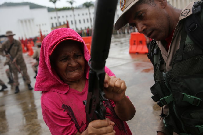 Một cụ bà Venezuela được hướng dẫn cách sử dụng súng trong cuộc diễn tập ở thủ đô Caracas ngày 26-8 - Ảnh: Reuters