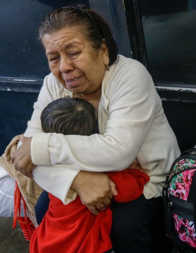 Bà Neri Sanchez khóc và ôm cháu trai bà, Jonathan Sanchez mới 1 tuổi, sau khi gặp lại cháu trên một thuyền cứu hộ chạy dọc Edgebrook Drive ở Houston - Ảnh: DALLAS NEWS