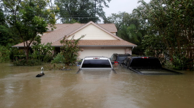 Nhà cửa và xe cộ chìm trong nước lụt ở phía đông TP Houston ngày 28-8 - Ảnh: REUTERS