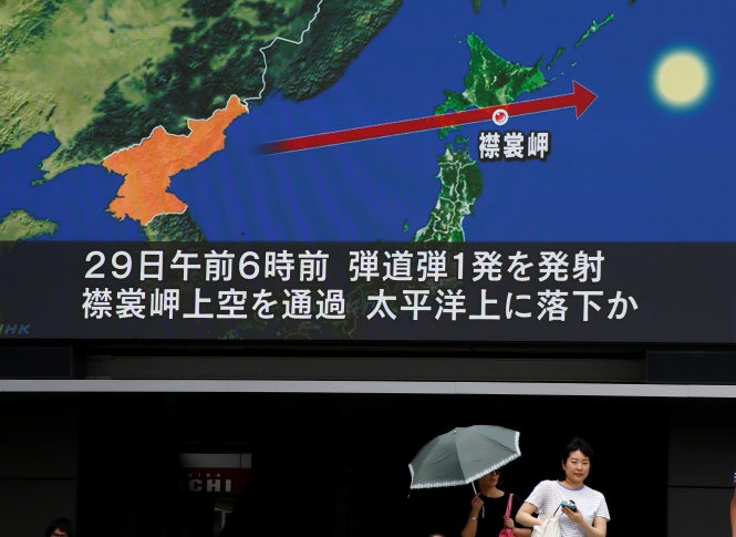 Hướng đi của tên lửa phóng đi từ Triều Tiên thể hiện trên màn hình ở  thủ đô Tokyo của Nhật sáng 29-8 - Ảnh: REUTERS