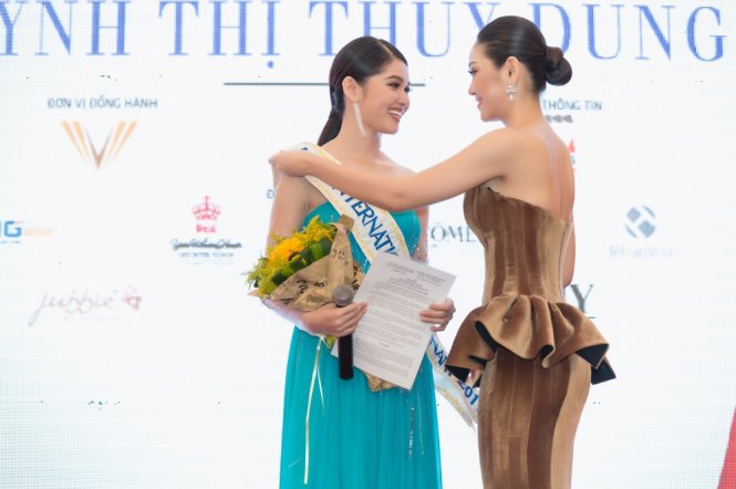 Á hậu Thuỳ Dung (trái) được Á khôi Áo dài 2016 Phương Linh, đại diện Việt Nam tại Hoa hậu Quốc tế 2016 trao băng đeo Miss International Vietnam 2017 - Ảnh: KIỆT VÕ - HUY NGUYỄN