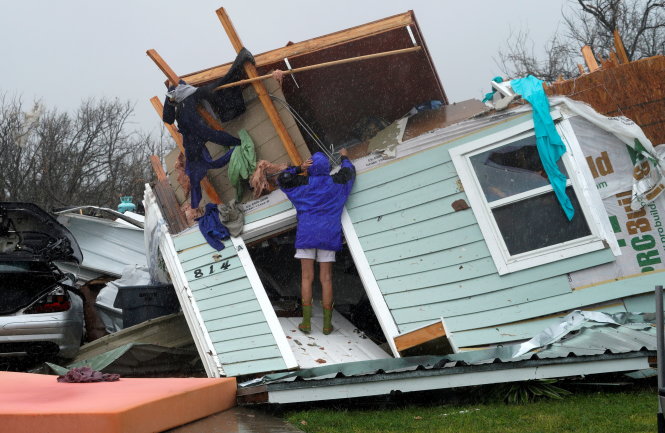 Bà chủ nhà ở TP Fulton, bang Texas tìm kiếm những món đồ còn dùng được trong ngôi nhà của mình bị bão Harvey đánh sập - Ảnh: REUTERS
