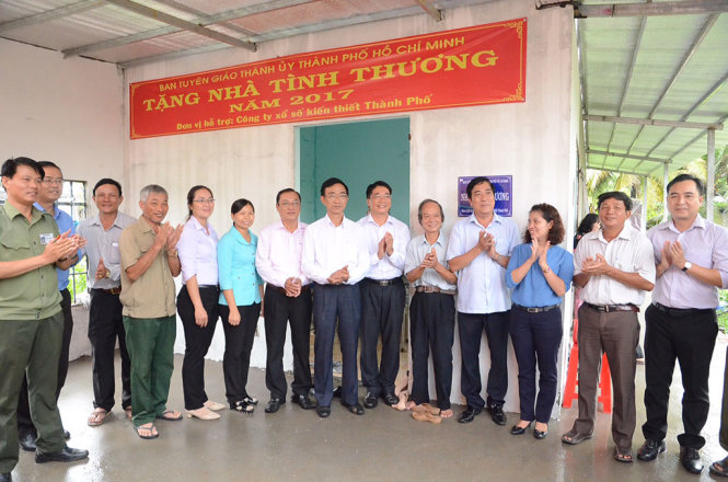 Phó Trưởng ban Tuyên giáo Thành ủy Tô Đại Phong chụp ảnh lưu niệm trao nhà tình thương cho gia đình ông Nguyễn Trường Thanh - Ảnh: LA MY