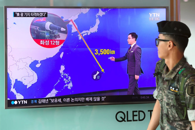 Binh sĩ Hàn Quốc xem màn hình thông tin về khả năng tên lửa của Bình Nhưỡng bấn đến đảo Guam của Mỹ - Ảnh: REUTERS