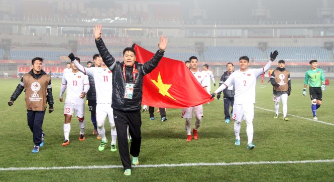 Các cầu thủ VN cầm cờ Tổ quốc ăn mừng tấm vé vào tứ kết Giải U-23 châu Á 2018. Ảnh: NGUYÊN KHÔI