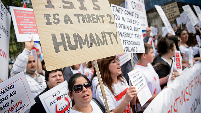 Người biểu tình phản đối hành động của IS ở London (Anh) với tấm biển ghi: “IS là mối đe dọa đối với nhân loại” - Ảnh: AFP