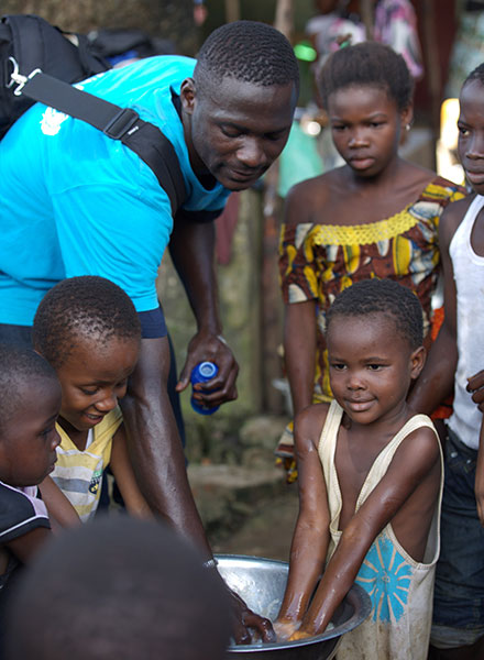 Nhân viên tình nguyện đi tuyên truyền, hướng dẫn trẻ em cách vệ sinh phòng dịch ở thủ đô Conakry của Guinea - Ảnh: Reuters