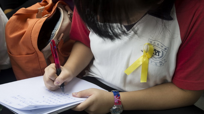 Một học sinh trung học Hong Kong đeo dải ruy băng vàng để thể hiện sự ủng hộ cuộc biểu tình Ảnh: Reuters