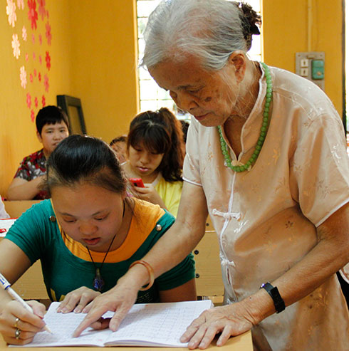 Bà Hồ Hương Nam ân cần động viên, chỉ dạy từng em trong lớp - Ảnh: V.Đồng