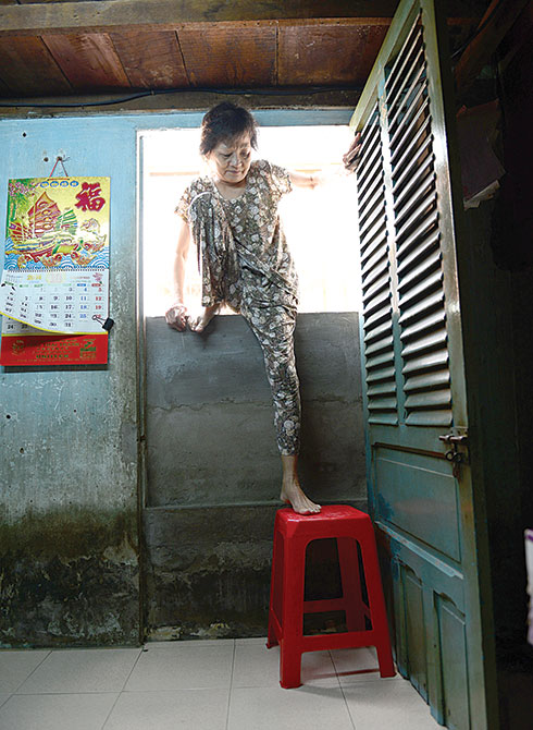 Bà Nguyễn Thị Hoài đặt ghế nhựa ngay cửa để lên xuống nhưng vẫn rất thấp so với mặt đường