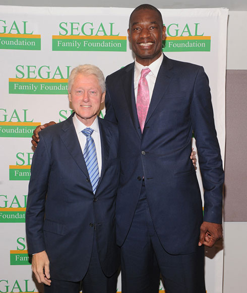 Danh thủ Dikembe Mutombo (phải) đứng bên cựu tổng thống Mỹ Bill Clinton - Ảnh: AFP