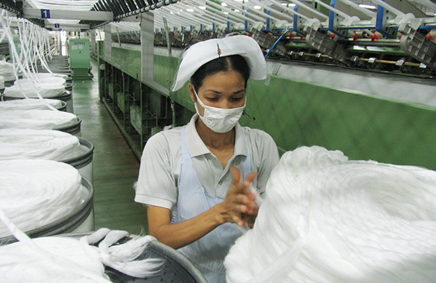 Giá dầu giảm đã kéo theo nguyên liệu sợi trên thế giới giảm 6,5-10%. Trong ảnh: sản xuất sợi tại Tổng công ty CP Phong Phú - Ảnh: T.V.Nghi