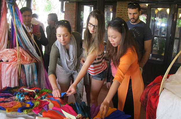 Du khách nước ngoài xem sản phẩm tơ lụa tại ngày hội - Ảnh: Thanh Ba