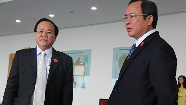 Ông Lê Thanh Cung (trái) và ông Trần Văn Nam (phải) trao đổi bên lề kỳ họp của HĐND tỉnh Bình Dương ngày 30-12 - Ảnh: Bá Sơn