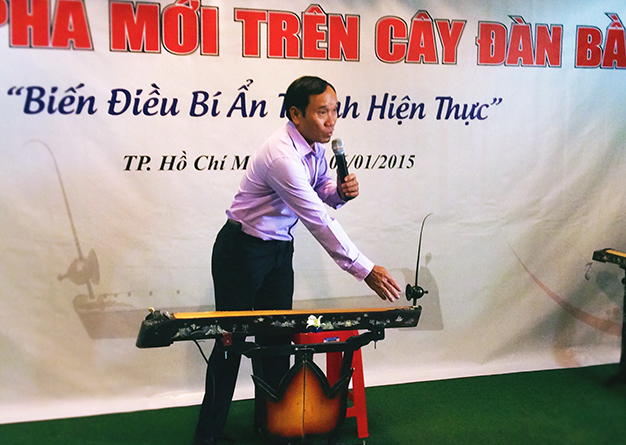 Mai Đình Tới giới thiệu về cây đàn bầu cải tiếng trong buổi ra mắt - Ảnh: Minh Trang