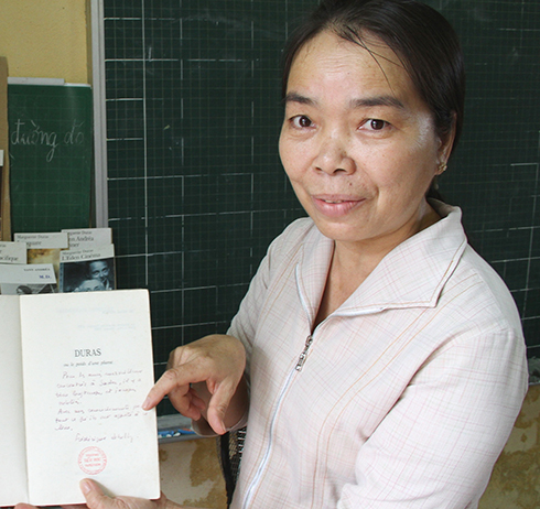 Cô Lao Thị Tư (giáo viên Trường tiểu học Trưng Vương, Sa Đéc) giới thiệu những quyển sách của M.Duras do người thân của nữ văn sĩ tặng - Ảnh: V.Tr.