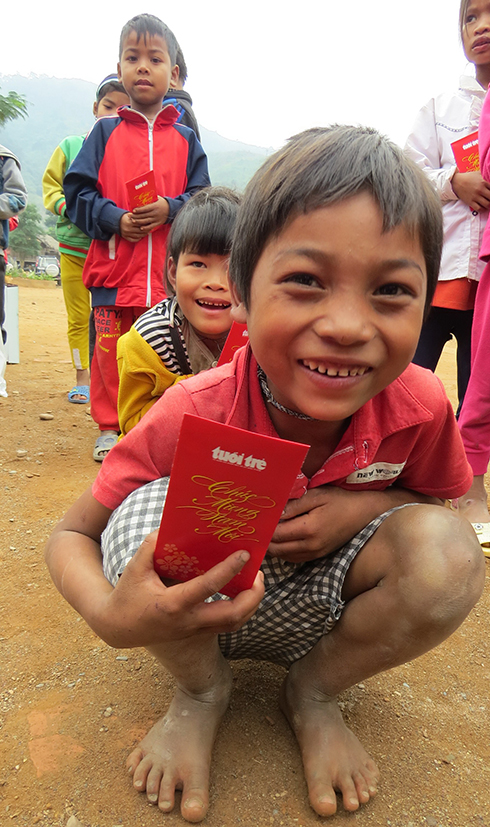 Em Hồ Văn Mai, học sinh lớp 4A Trường tiểu học Hưng, xã Trọng Hóa (Minh Hóa, Quảng Bình) chân đất đi nhận quà tết - Ảnh: Q.Nam