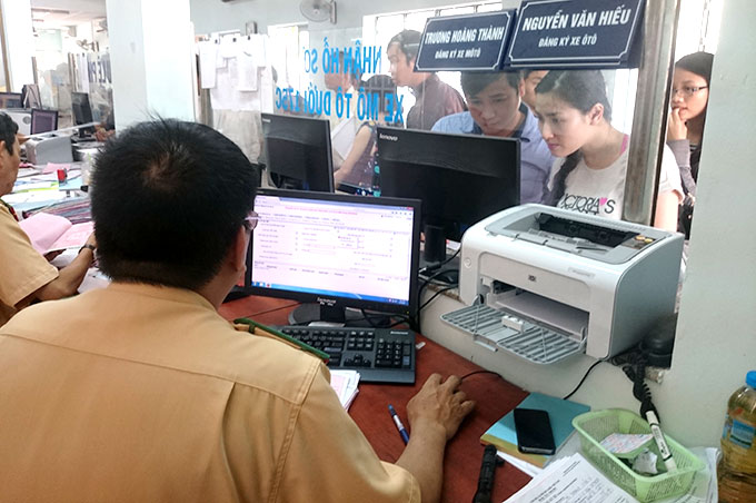 Người dân chọn biển số xe bằng cách bấm máy ngẫu nhiên tại 282 Nơ Trang Long, Q.Bình Thạnh, TP.HCM - Ảnh: Đ.Thanh