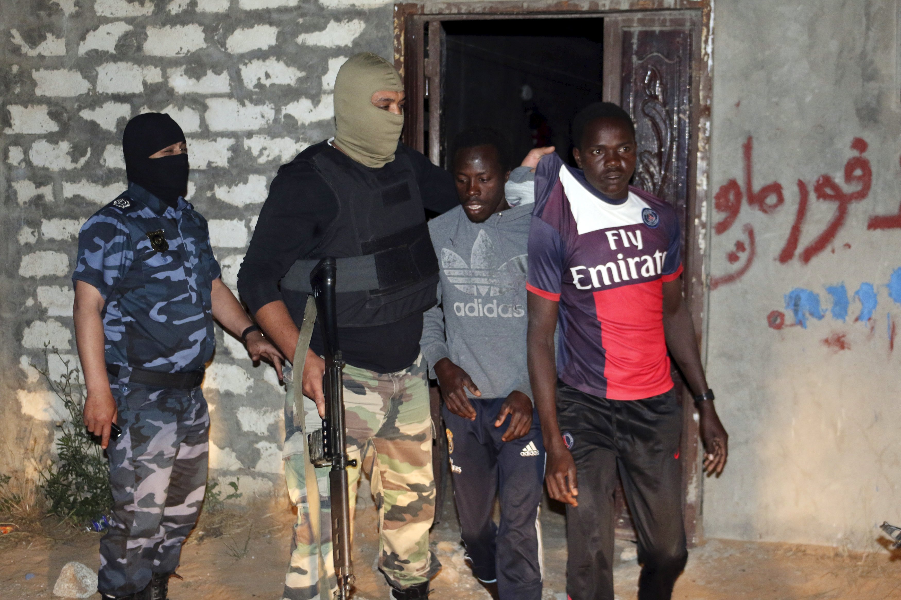 Lực lượng an ninh Libya bắt những người nghi là di dân từ châu Phi đang tập kết tại một địa điểm ở Tripoli, trong cuộc bố ráp rạng sáng 18-5  Ảnh: Reuters