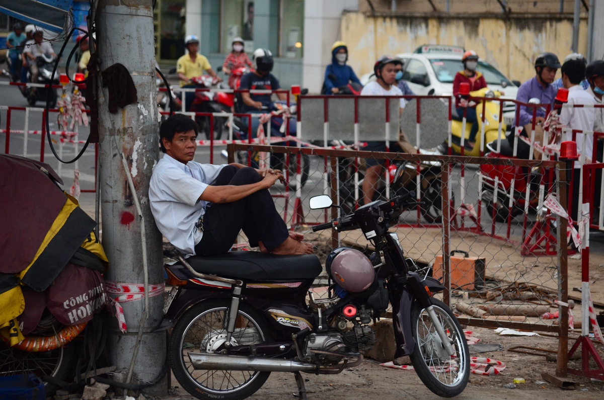 Người người chạy xe ôm ngồi kế lô cốt trên đường Nguyễn Kiệm, Q. Gò Vấp -Ảnh: Thanh Tùng