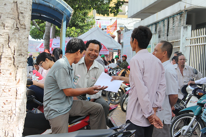 Những người cha tụ tập tám với nhau trước điểm thi trường Đại học Tiền Giang chờ con - Ảnh: Sơn Lâm