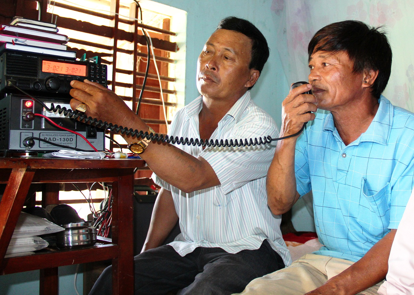 Ông Nam (trái) nối máy Icom cho chủ tàu Nguyễn Văn Quang nói chuyện với tàu QNg 90205 (hai lần bị cướp tài sản) - Ảnh: T.Mai