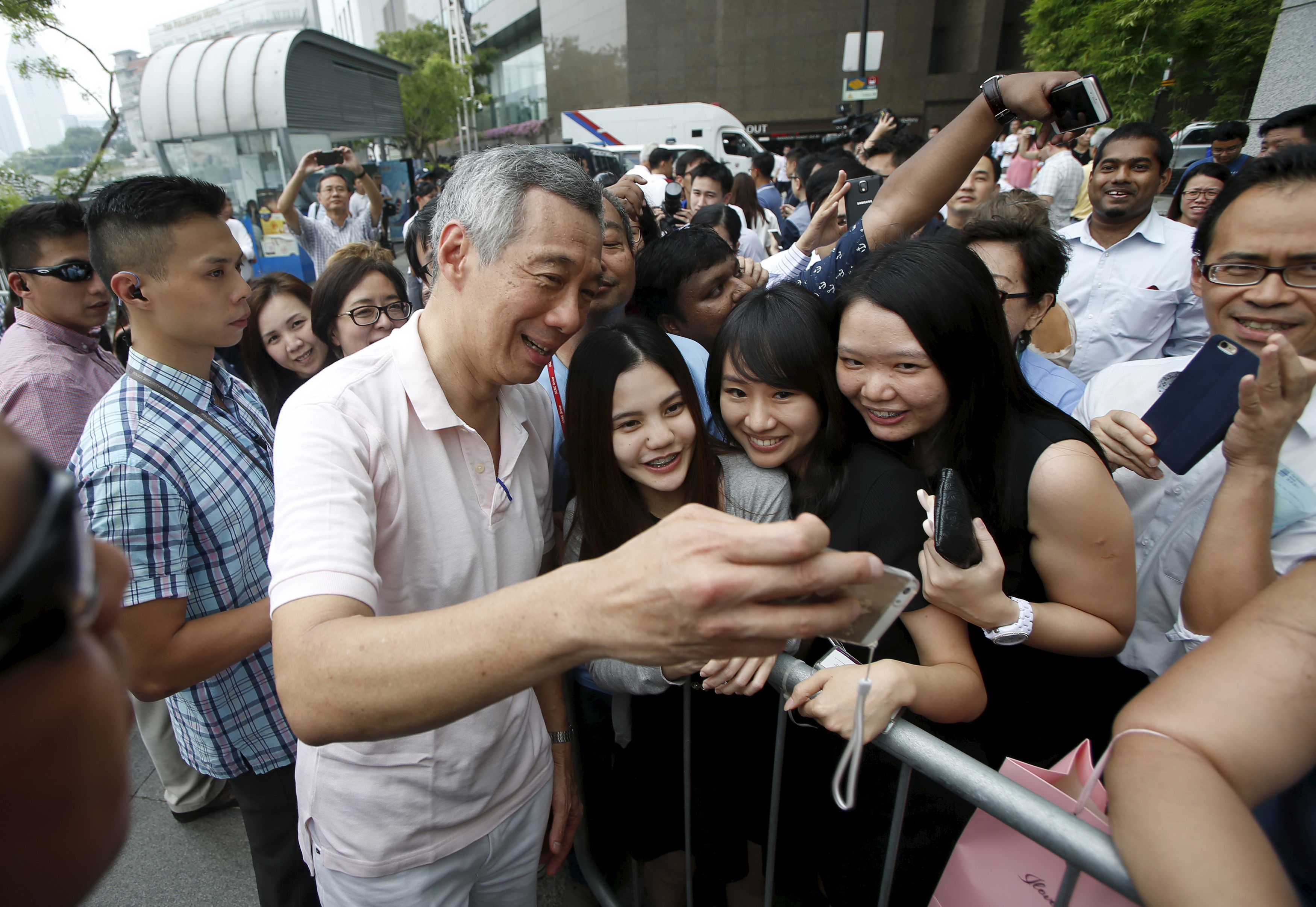 Thủ tướng Lý Hiển Long, lãnh đạo Đảng cầm quyền PAP, chụp ảnh selfie với các cử tri sau cuộc tuần hành tại khu trung tâm thương mại của Singapore ngày 8-9 - Ảnh: Reuters