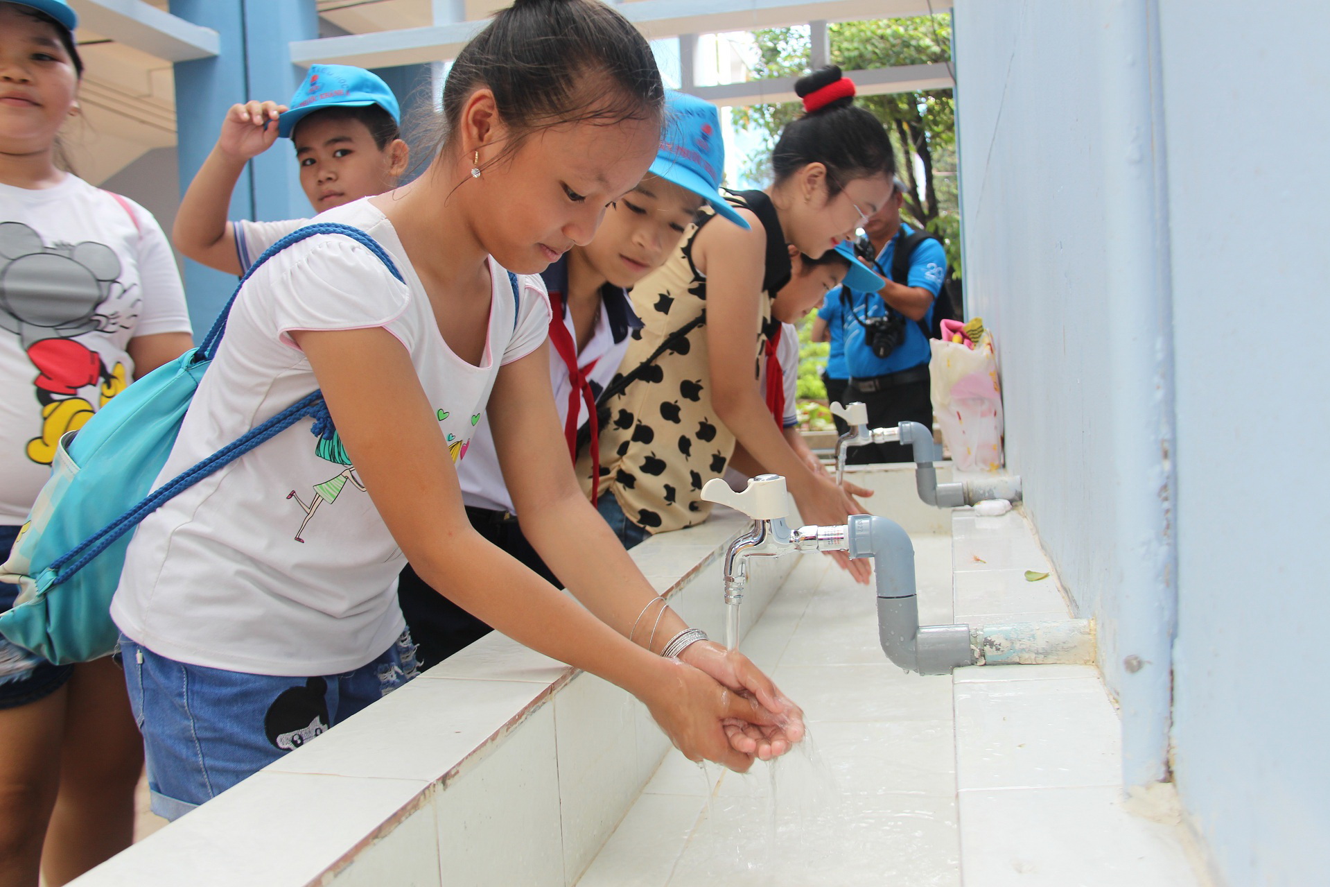 Học sinh rửa tay với nước sạch tại hệ thống nhà vệ sinh mới được tặng ở Trường tiểu học Tân Phước Khánh A - Ảnh: Bá Sơn