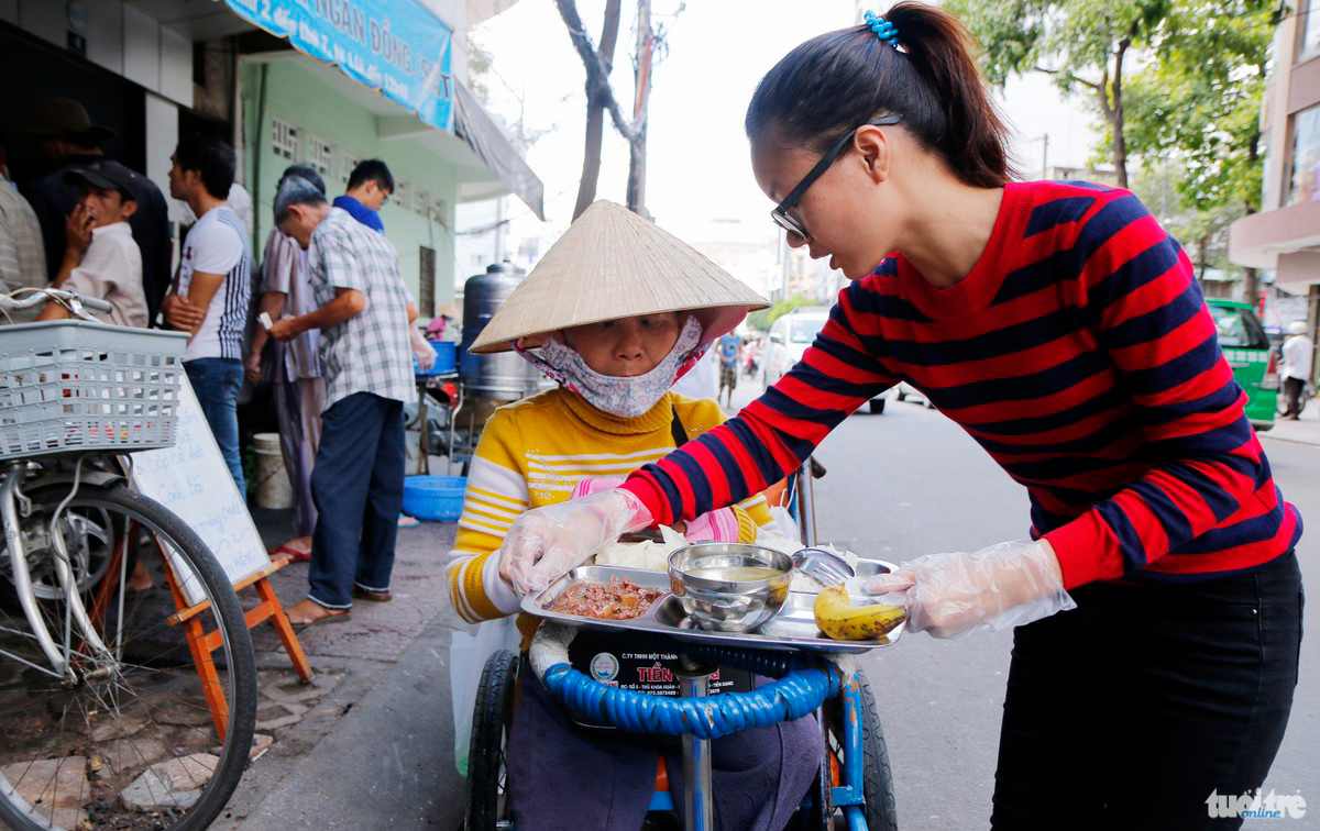 Chị Thanh (quê ở Quãng Ngãi) không thể đi được nên hôm nào cũng có Bạn Nguyễn Thị Thu Hiền (Q. Tân Bình) mang đĩa cơm ra phục vụ chu đáo - Ảnh: NGỌC DƯƠNG

