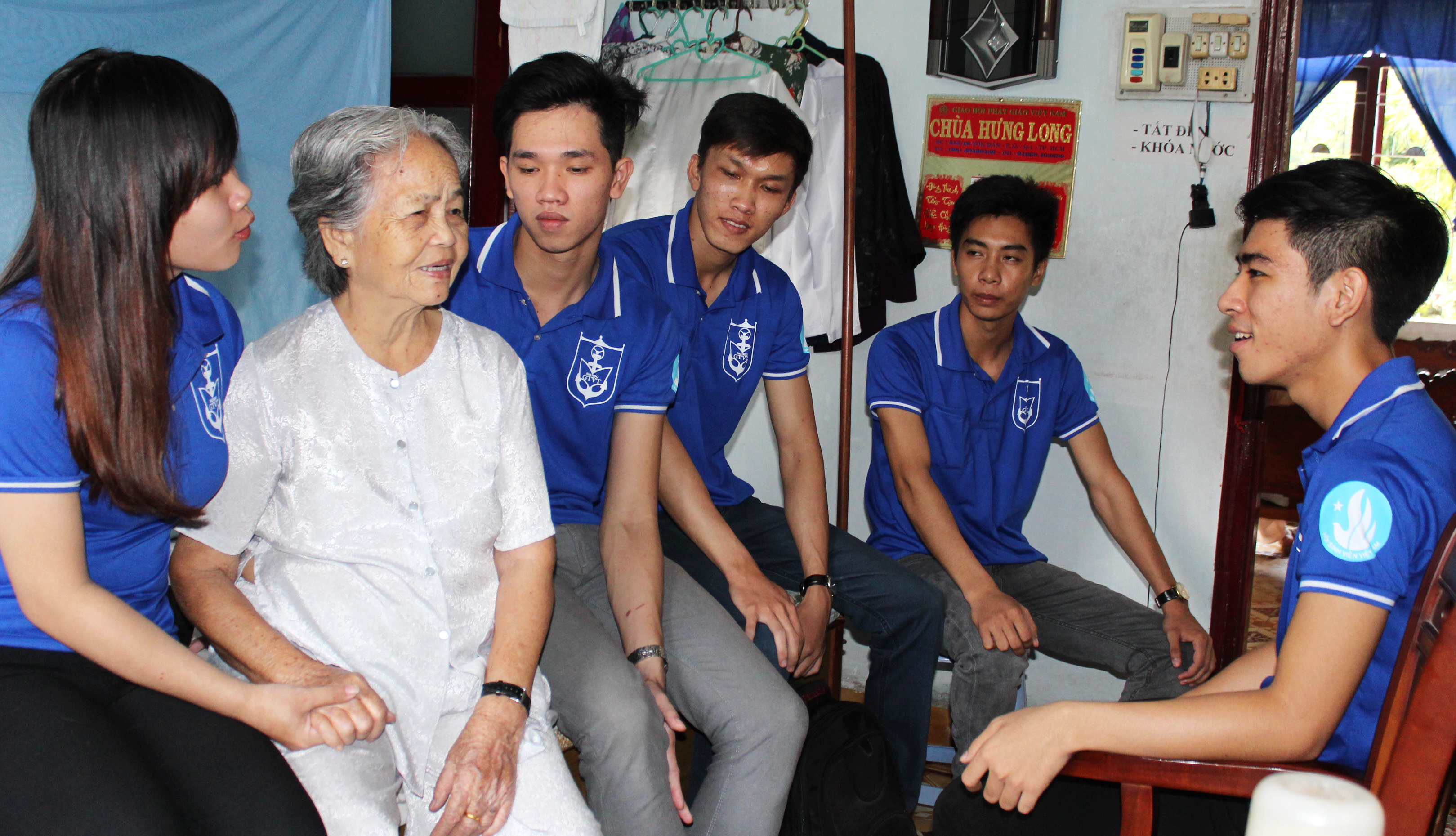 Các chiến sĩ Mùa hè xanh ĐH Giao thông vận tải TP.HCM đến thăm, tặng quà và trò chuyện cùng cụ Cao Thị Đậu (86 tuổi) tại Trung tâm Dưỡng lão Thị Nghè - Ảnh: Q.L.