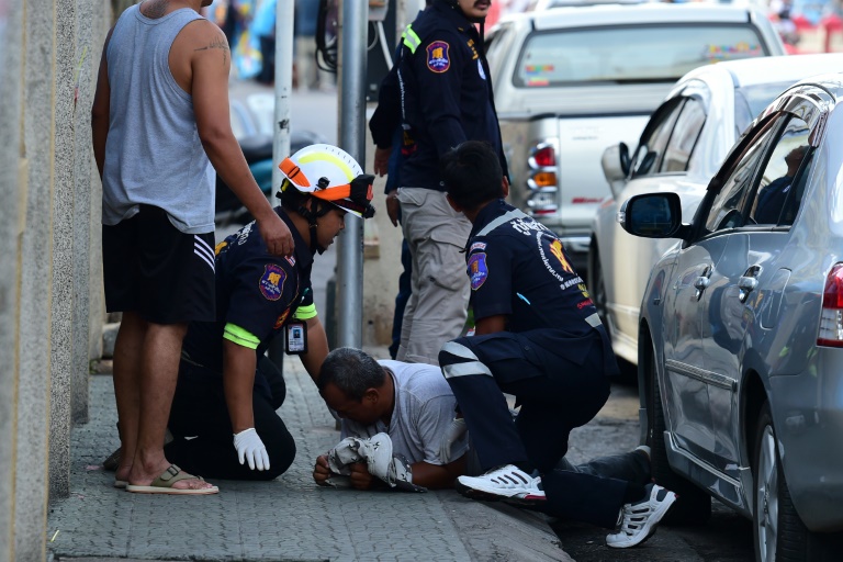 Nhân viên cứu hộ giúp đỡ một người đàn ông bị thương sau vụ nổ tại Hua Hin hôm 12-8 - Ảnh: AFP