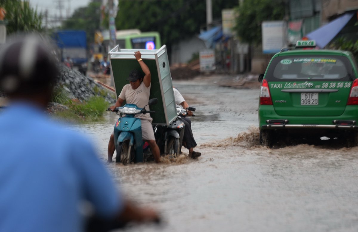 Người dân vất vả tại một đoạn ngập sâu trên đường

