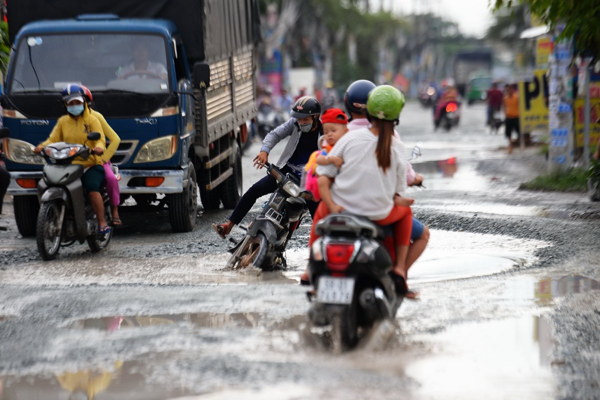 Một chiếc xe nghiêng đổ vì sụp “hố trâu” trên đường