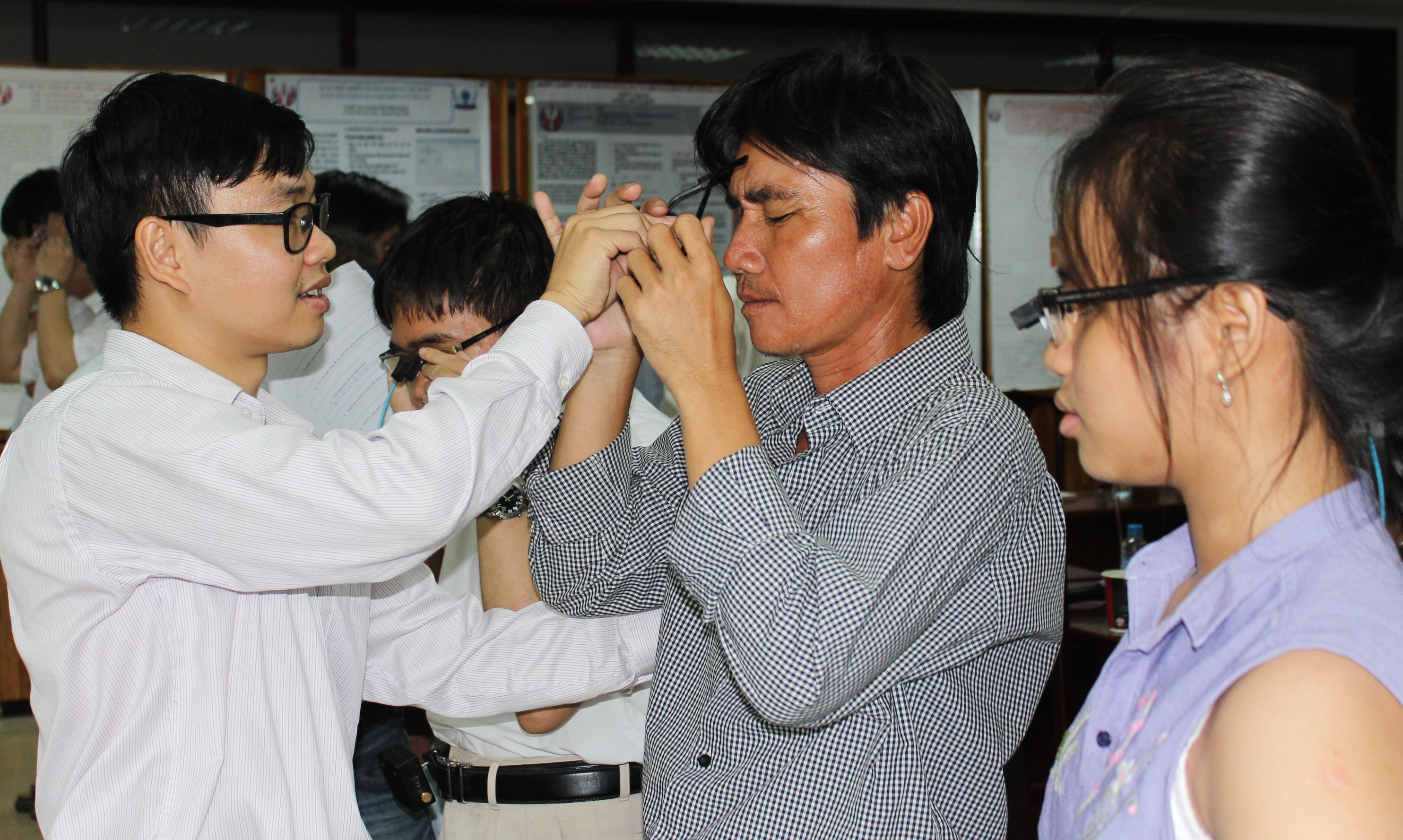 TS Nguyễn Bá Hải (bìa trái) giải thích tính năng mới và hướng dẫn người mù cách sử dụng 