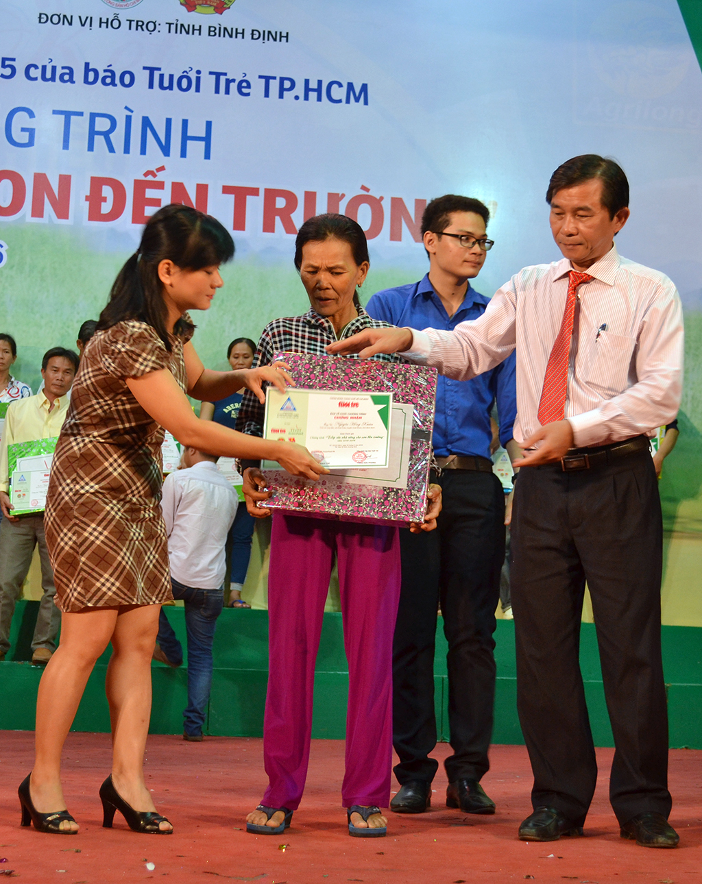 Ông Trần Châu - phó chủ tịch UBND tỉnh Bình Định – cùng đại diện một nhà tài trợ trao vốn cho nông dân - Ảnh: DUY THANH
