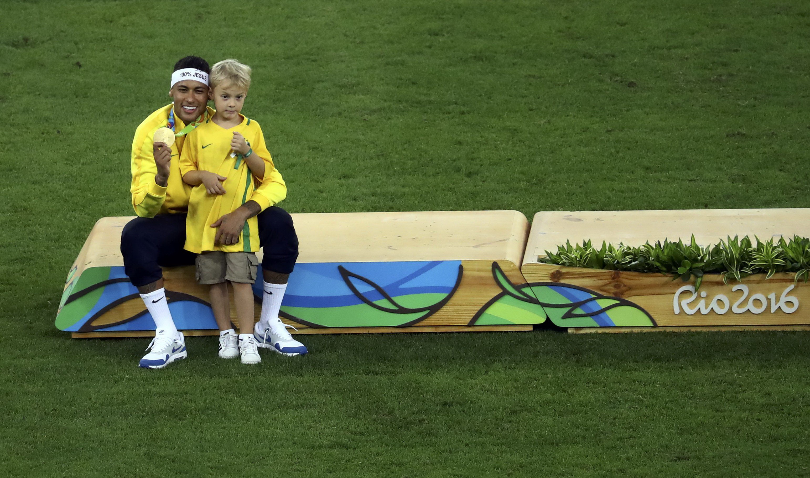 Neymar và con trai David Lucca chụp hình cùng tấm HCV Olympic môn bóng đá nam. Ảnh: REUTERS